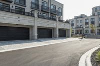 a grey colored street with a large garage in the middle of the road next to buildings