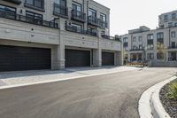 a grey colored street with a large garage in the middle of the road next to buildings