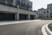 a grey colored street with a large garage in the middle of the road next to buildings