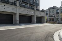 a grey colored street with a large garage in the middle of the road next to buildings