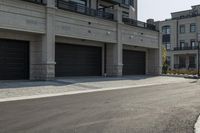 a grey colored street with a large garage in the middle of the road next to buildings