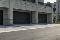 a grey colored street with a large garage in the middle of the road next to buildings