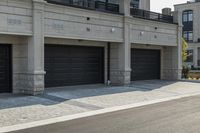 a grey colored street with a large garage in the middle of the road next to buildings