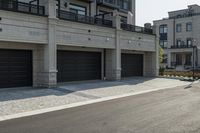 a grey colored street with a large garage in the middle of the road next to buildings