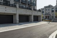 a grey colored street with a large garage in the middle of the road next to buildings