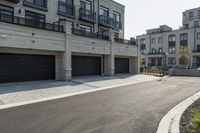 a grey colored street with a large garage in the middle of the road next to buildings