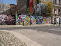 an empty street with a group of people on it and graffiti covered buildings in the background