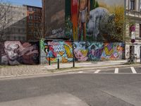 an empty street with a group of people on it and graffiti covered buildings in the background