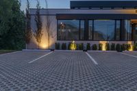 the front of a restaurant with lights and trees in the parking lot in front of it