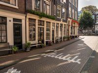 a street lined with buildings and benches on both sides of it on cobblestones