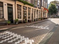 a street lined with buildings and benches on both sides of it on cobblestones