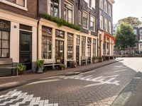 a street lined with buildings and benches on both sides of it on cobblestones