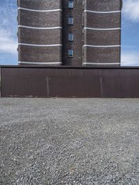 a big brick building near a wall and grass field on the ground area on top of the building