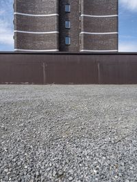 a big brick building near a wall and grass field on the ground area on top of the building