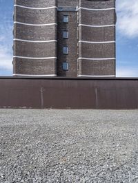 a big brick building near a wall and grass field on the ground area on top of the building