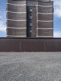 a big brick building near a wall and grass field on the ground area on top of the building