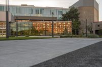 a city street surrounded by grass and tall buildings at the end of a street there is a paved pathway in front of the building