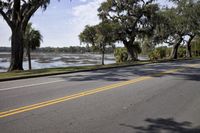 a car parked by a body of water with trees and grass around it in front
