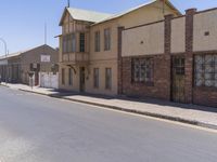 a building with the sign that reads to the right of the road is a closed street, with a yellow line on the road in front of it, and some buildings