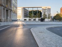 a paved road with cars driving down it that looks like a roundabout of gravels