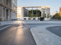 a paved road with cars driving down it that looks like a roundabout of gravels