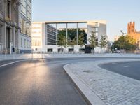 a paved road with cars driving down it that looks like a roundabout of gravels