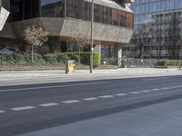 a city street with multiple buildings and two bikes on the road, one empty, one parked