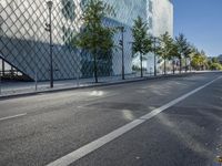 a street with a few people on it and a building in the background with a diamond patterned glass structure