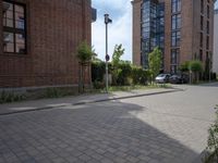 the sidewalk is brick with a planter in between the sidewalks to the side and a door leading out onto street