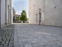 a narrow stone road that leads down to buildings and trees next to them with windows