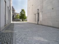 a narrow stone road that leads down to buildings and trees next to them with windows