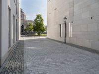 a narrow stone road that leads down to buildings and trees next to them with windows