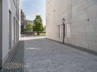 a narrow stone road that leads down to buildings and trees next to them with windows