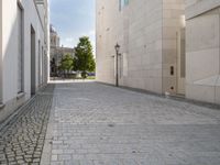 a narrow stone road that leads down to buildings and trees next to them with windows