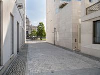 a narrow stone road that leads down to buildings and trees next to them with windows