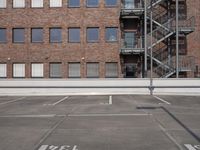 an empty parking lot with stairs and windows in the background with no parking signs on it