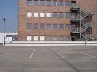 an empty parking lot with stairs and windows in the background with no parking signs on it