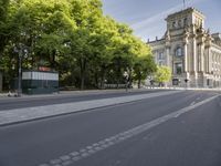 the view of an empty street with two buses in front of it and a building behind