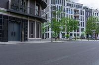 an image of a street with some buildings and trees near by and on the side