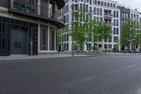 an image of a street with some buildings and trees near by and on the side