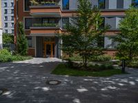 a residential driveway with a bench and bushes in between buildings and green grass on either side