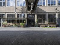 the entrance to a business with a walkway between two buildings and a bench on both side