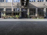 the entrance to a business with a walkway between two buildings and a bench on both side