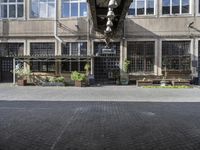 the entrance to a business with a walkway between two buildings and a bench on both side