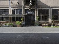 the entrance to a business with a walkway between two buildings and a bench on both side