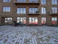 a motor cycle parked in front of a building and chairs and tables in the grass