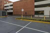 the parking space in front of this brick building has multiple parking spaces along side of it