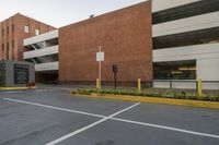 the parking space in front of this brick building has multiple parking spaces along side of it