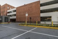 the parking space in front of this brick building has multiple parking spaces along side of it