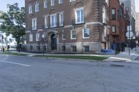 an apartment building at the corner of a street with a blue fire hydrant in front